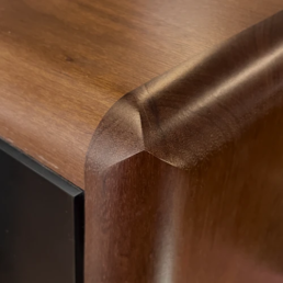 Gros plan sur la finition soignée et l'angle arrondi en bois naturel de l'enceinte haute fidélité Grand Monitor Pro.