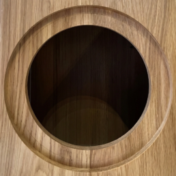 Vue rapprochée d'une découpe circulaire parfaite dans le boîtier en bois massif de l'enceinte ASA Grand Monitor Pro pour le boomer, révélant l'épaisseur de 32 mm et la structure interne dense.